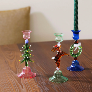 Three decorative glass candle holders on a wooden surface