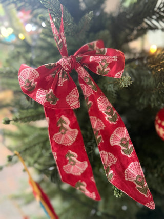 Red ribbon with a floral pattern tied on a Christmas tree