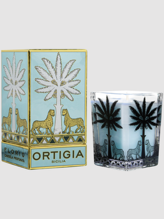 Candle with palm tree design and packaging featuring Ortigia branding on a white background