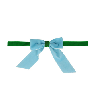 Green headband with a large blue bow on a white background