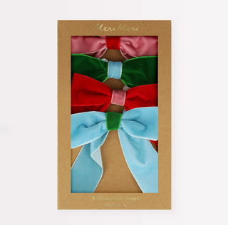 Set of colorful fabric bows in a Meri Meri branded box on a light beige background