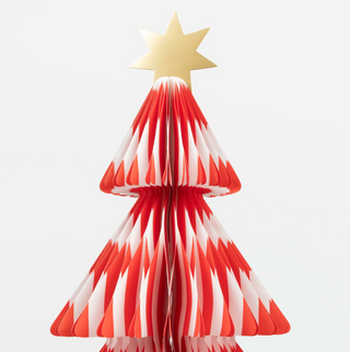 Red and white striped paper Christmas tree with a gold star on a light gray background