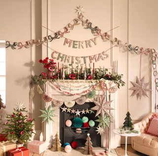 Decorated living room with Christmas mantel, garlands, and festive decorations.