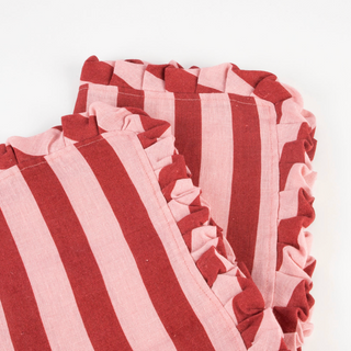Close-up of red and white striped fabric with ruffled edges on a white background