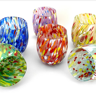 Set of colorful glass tumblers with abstract patterns on a white background