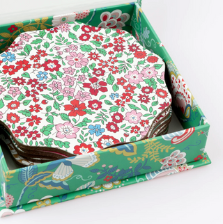 Floral-patterned coasters in a decorative box on a white background