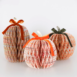 Three decorative paper pumpkins with ribbons on a white background