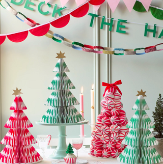 Decorative Christmas trees made from paper and candy on a table with festive decorations.