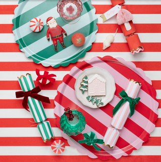 Christmas-themed trays and crackers on a red and white striped background